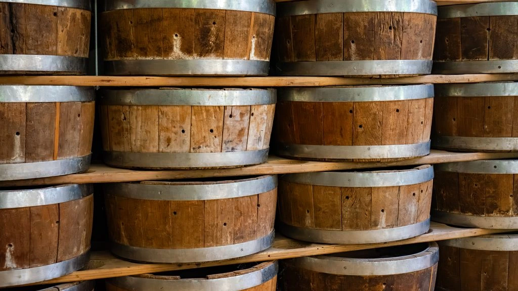Sepia-toned scanned plate of a Louisville cooperage room with stacked oak bourbon barrels.